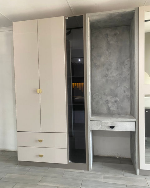 Our showroom BIC with cotton texture doors, basalt texture carcasses and elmina stucco feature units in between. Handles are black and brushed brass cup handles. A mirror cut-out unit and a tinted glass door shelving unit stand out along side a vanity and window nook.