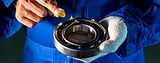 Mechanic applying grease to a bearing; Chemlube lubrication for industrial equipment needs.