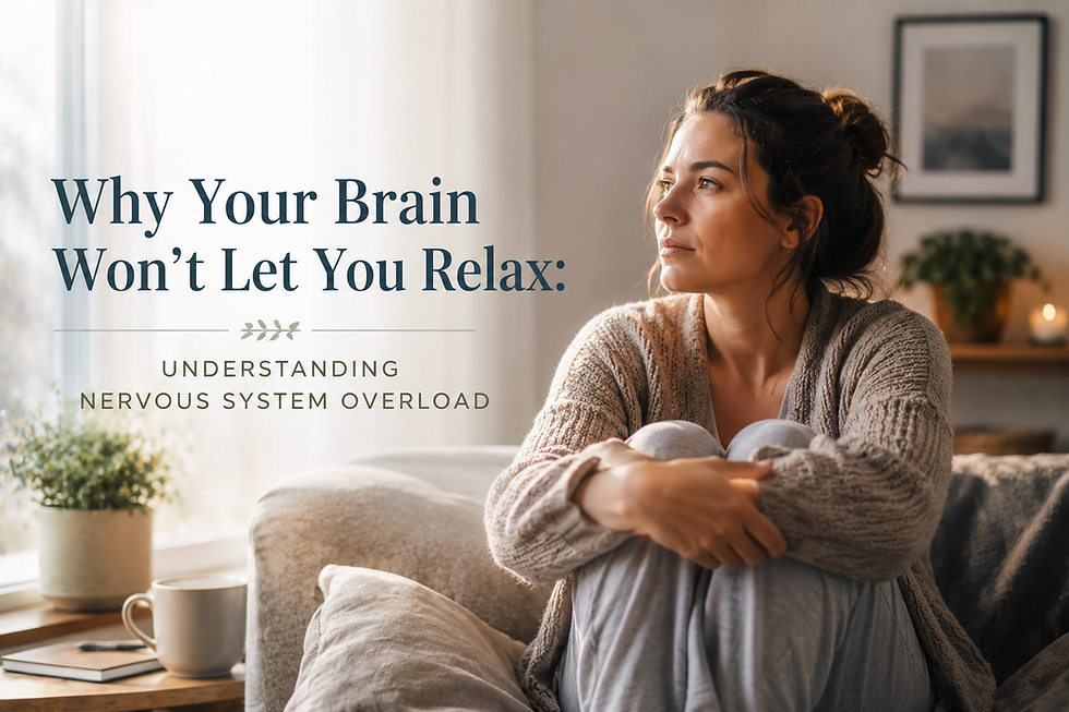A thoughtful woman sitting quietly on a couch in a softly lit living room, representing chronic stress, emotional overwhelm, and nervous system overload.