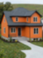 Two-story orange house, dark roof, pathway