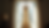 Eye-level view of a bride’s lace wedding dress hanging by a window with soft natural light