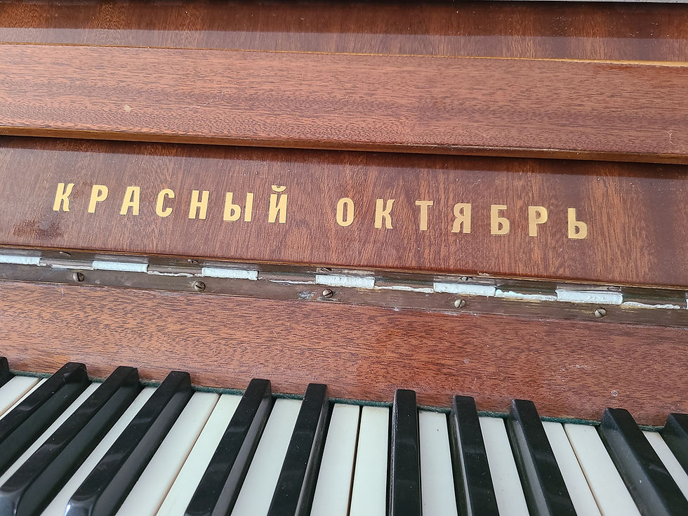 תמונת פסנתר קיר עליו כתוב ברוסית "אוקטובר האדום" שם הפסנתר