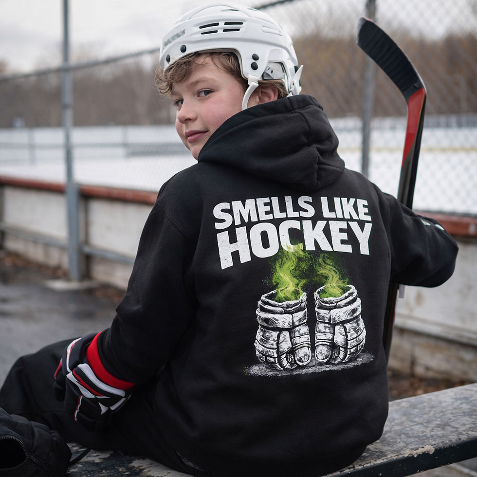 Back view of youth hockey player wearing black Smells Like Hockey hoodie with hockey gloves graphic at an ice rink
