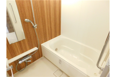 Modern bathroom with a bathtub, shower, and wooden wall panels.