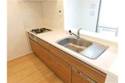 Modern kitchen with white countertops, wooden cabinets, and stainless steel sink.