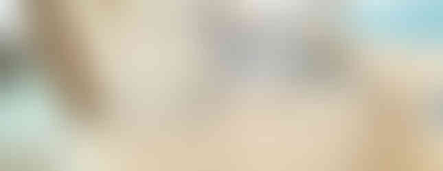 The photo shows a small laundry area with a stainless steel sink and white cabinets. The walls are tiled in a light blue and white pattern, and there is a window above the sink. The laundry area appears clean and well-maintained.