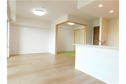 Modern Japanese apartment living room with tatami room, kitchen counter, and wooden floors.