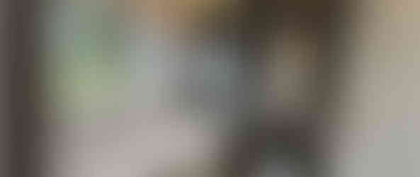 Modern bathroom interior with a bathtub, window for natural light, and a mirror.