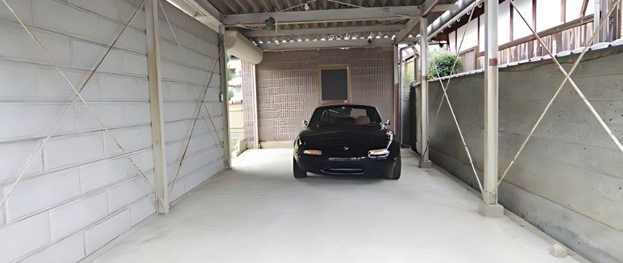 A black Mazda MX-5 sports car parked in a garage.