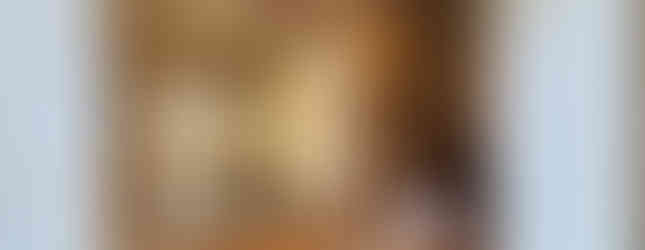 A traditional Japanese-style entrance hall with tatami mats and wooden walls. There are sliding doors leading to other rooms and a staircase to the second floor. There are slippers on the floor and a small garden visible through the window.