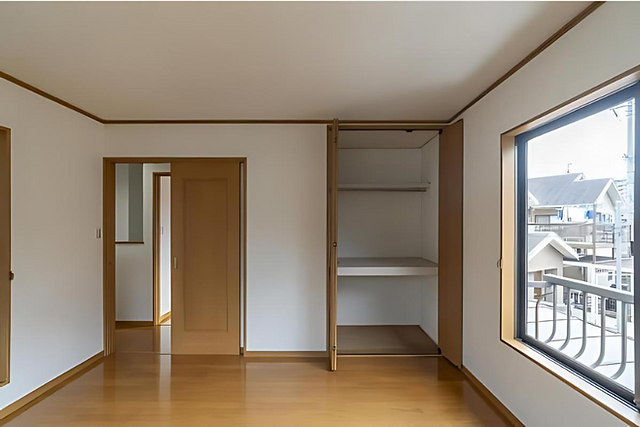 Empty room in a renovated house featuring a closet with sliding doors and a window with blinds.
