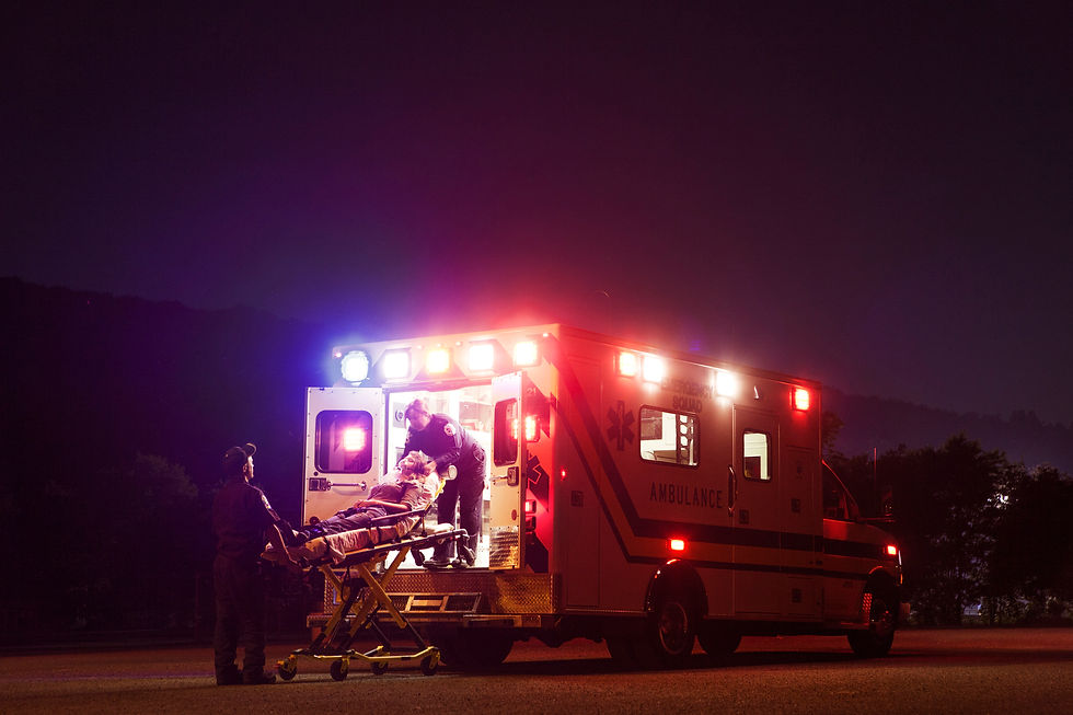 Two EMS personnel loading a patient into an ambulance