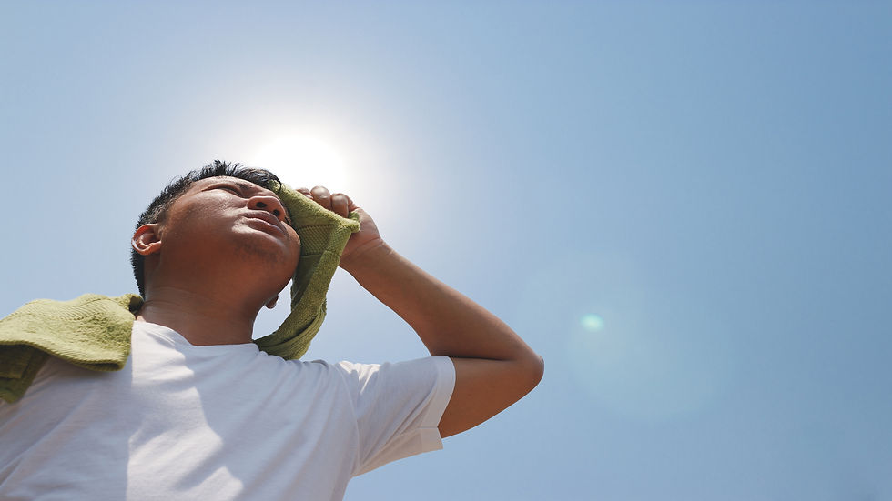 Photo of a man wiping sweat off his face with a towel