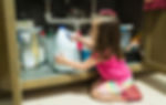 A child reaching for bleach underneath a sink