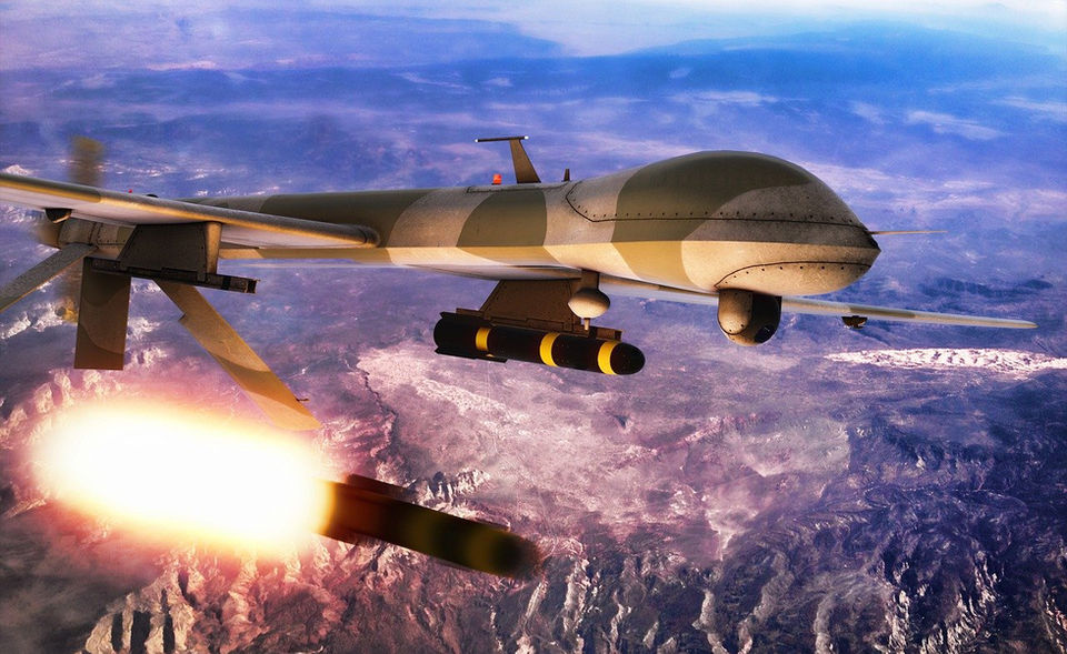 Military drone plane flying over the desert firing a missile.