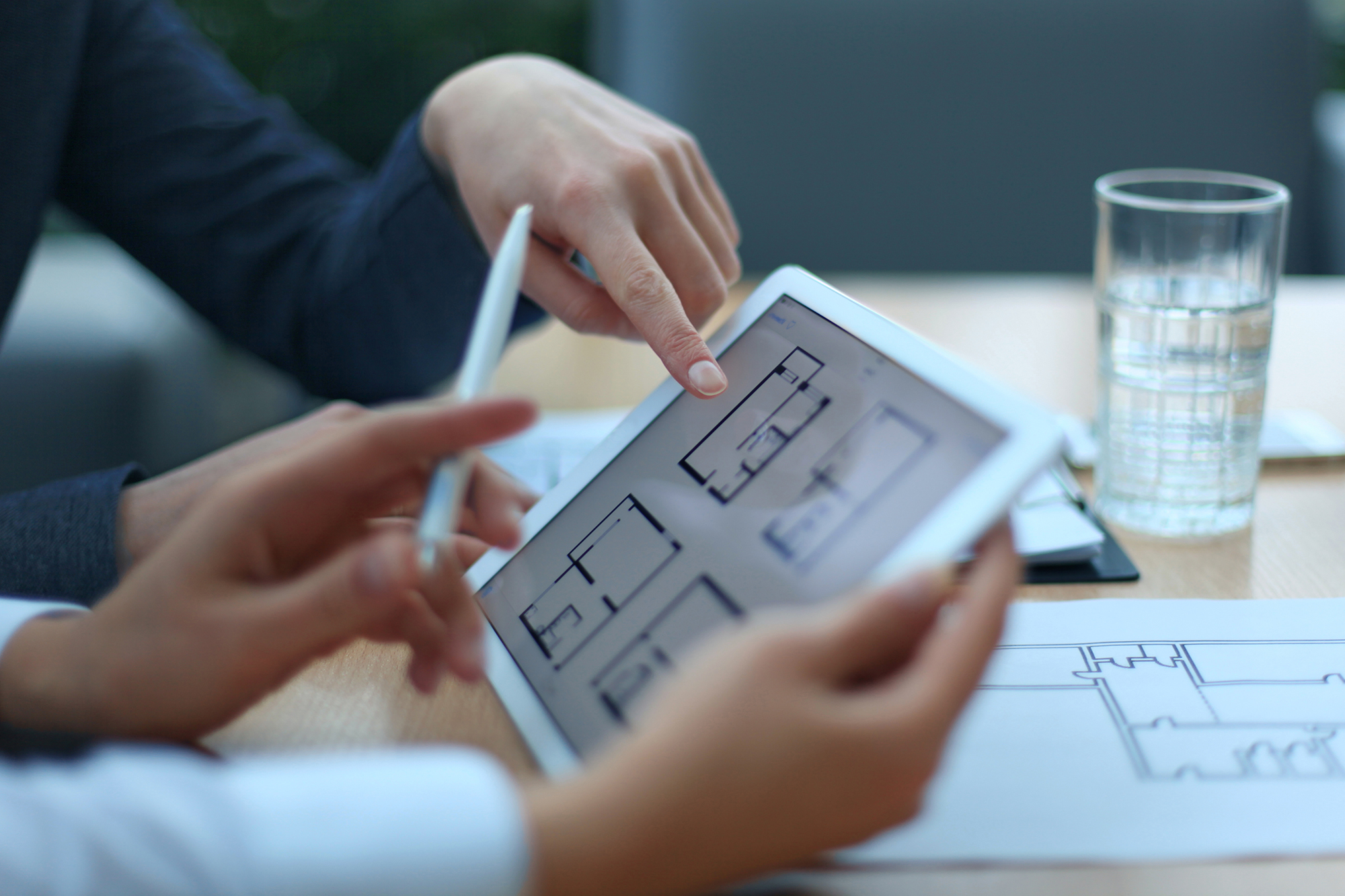 Profesionales revisando planos arquitectónicos para una valoración inmobiliaria
