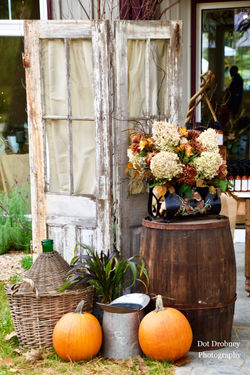 unique fall floral arrangement with dried hydrangea peacock feathers in antique magazine rack