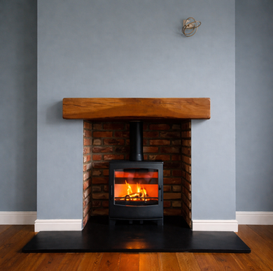 Black wood-burning stove with visible flames inside a red brick fireplace, topped with a wooden mantel and set against a blue-grey wall.