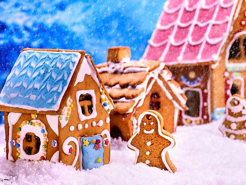3 gingerbread houses with a gingerbread man standing in front