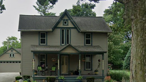 a forest green gothic revival two story house