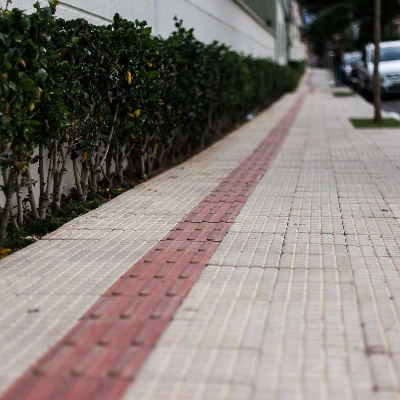 piso tátil de concreto direcional e alerta instalado em calçada para acessibilidade