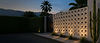 Fachada residencial contemporânea com muro de cobogó de concreto iluminado, paisagismo sofisticado e portão metálico em projeto arquitetônico de alto padrão.