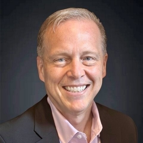 Smiling male associate in a suit and pink shirt