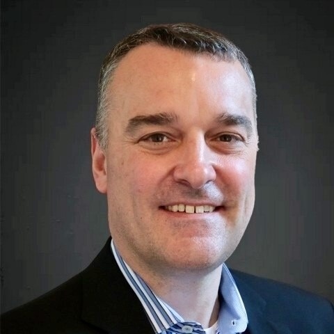 Smiling male associate in a suit and collared shirt