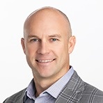 Smiling bald man in a grey plaid blazer.