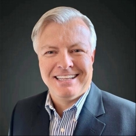 Smiling male associate with grey hair in a suit jacket