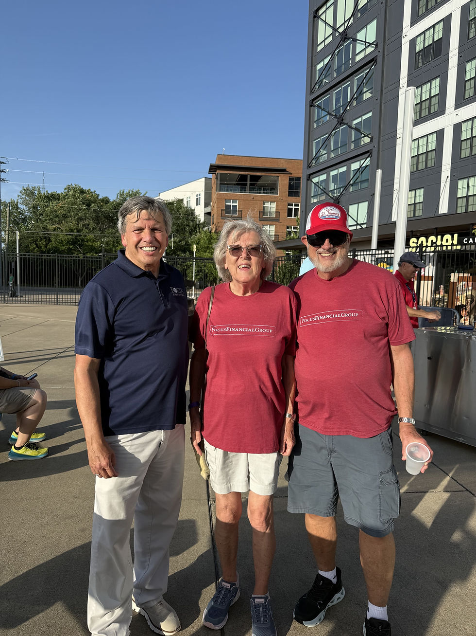 Three smiling team members standing together outdoors.