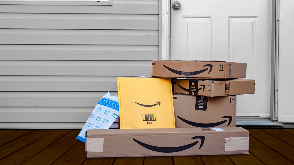 Stack of amazon deliveries outside a front door.