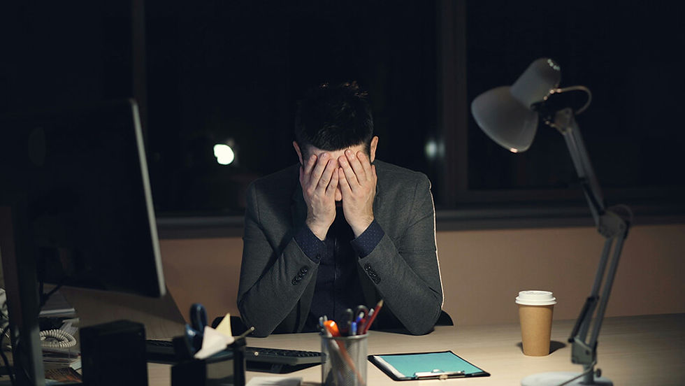 Person experiencing workplace burnout while working on a laptop, representing chronic stress and nervous system exhaustion before EMDR therapy in Vancouver or online across BC.