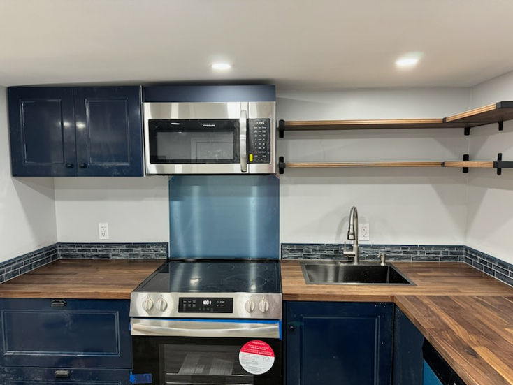 a kitchen with a stainless steel stove top oven and a frigidaire microwave