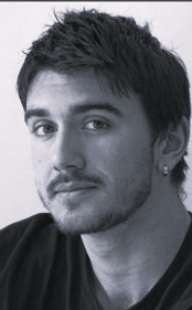 Young man with dark hair and a beard, looking directly at the camera.