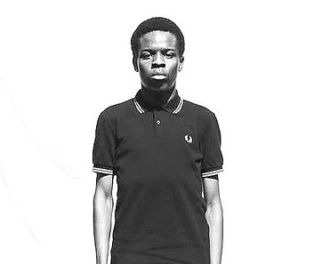 Young man wearing Fred Perry shirt, looking at the camera in studio lighting.
