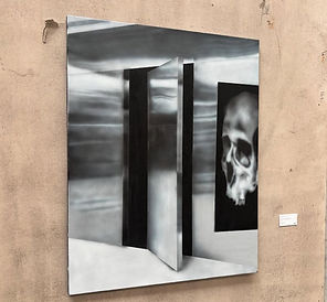 Abstract art of an open door and a skull, on a light-colored wall.