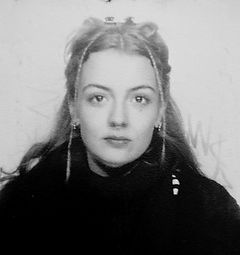 Headshot of a blonde woman with long hair and a black top.