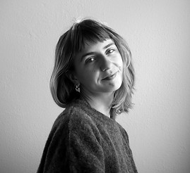 Smiling woman with short hair poses for a black and white portrait photo.