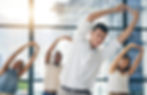 people in an office stretching and doing yoga