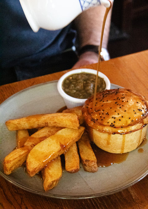 Award winning homemade pies with gravy being poured at Crown and Anchor Barugh Green