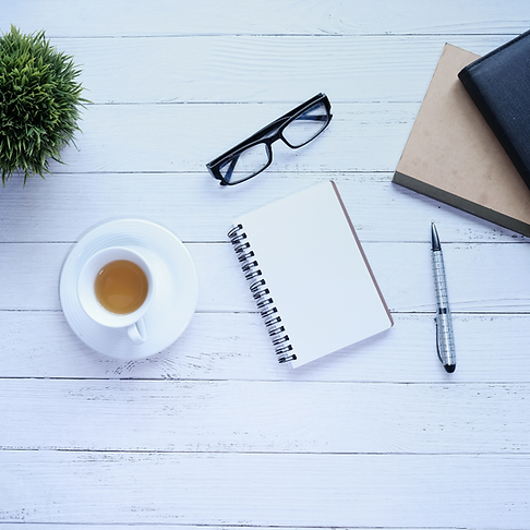 a-cup-of-tea-a-notebook-a-pen-and-some-spectacles-on-a-desk