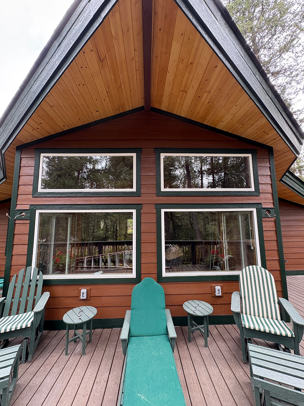 Eye-level view of a renovated lakeside cabin exterior with new Trex decking and picket railing