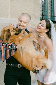 Bride and groom posing with dog.