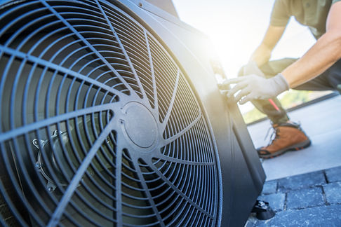 A technician is performing maintenance on an air conditioning unit located on a rooftop. T