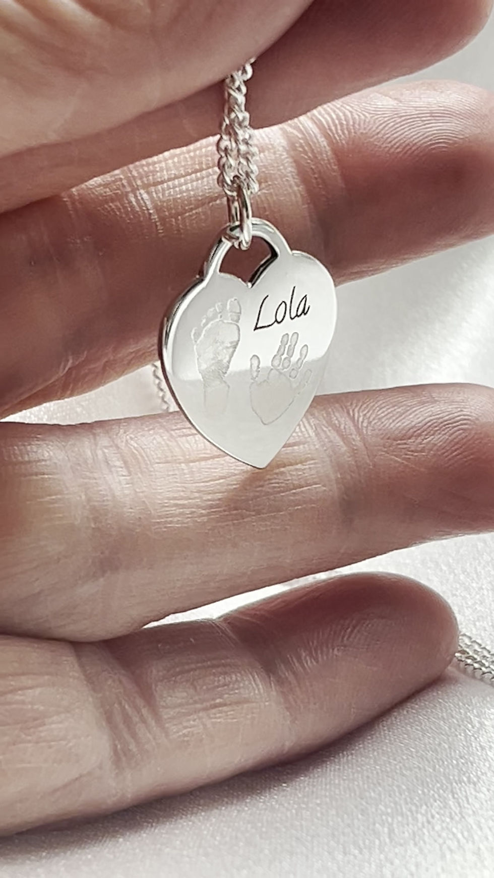Thumbnail: Max Silver Baby Hand and Footprint Heart Keepsake Necklace showing the front of the pendant (hand, foot and name)