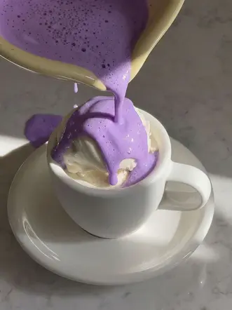 Ubelogy Ube latte poured over vanilla ice cream in an affogato-style dessert cup
