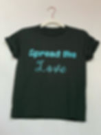 A green shirt with blue writing that says "Spread the Love". Available for purchase through website. 