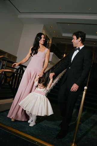Wedding guests entering the event at Bride standing in the middle of her bridesmaids wearing soft pink pastel gowns at the beachfront terrace of the San Juan Marriott Resort and Stelaris Casino