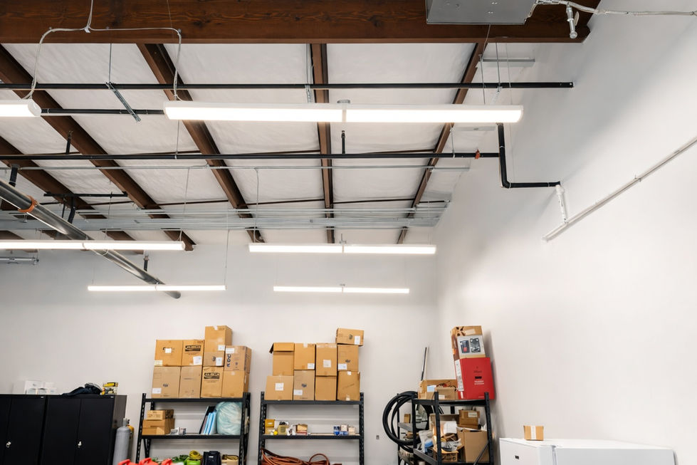 Warehouse and storage area at National Mechanical Headquarters in Cornelius, NC, showing exposed wood beam ceiling, black pipe infrastructure, linear LED lighting, and organized shelving with cardboard boxes after interior upfit design by Held Architecture